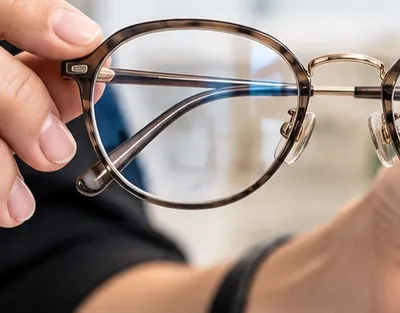 Lentes de armazón carey en la mano
